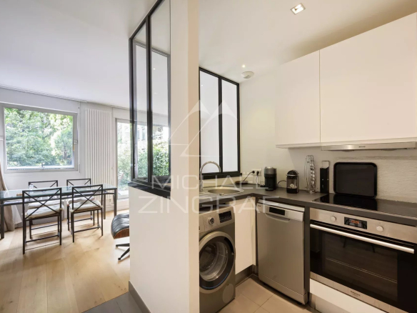 Cuisine moderne avec coin repas, ouverte sur un jardin, dans un appartement à Neuilly-sur-Seine.