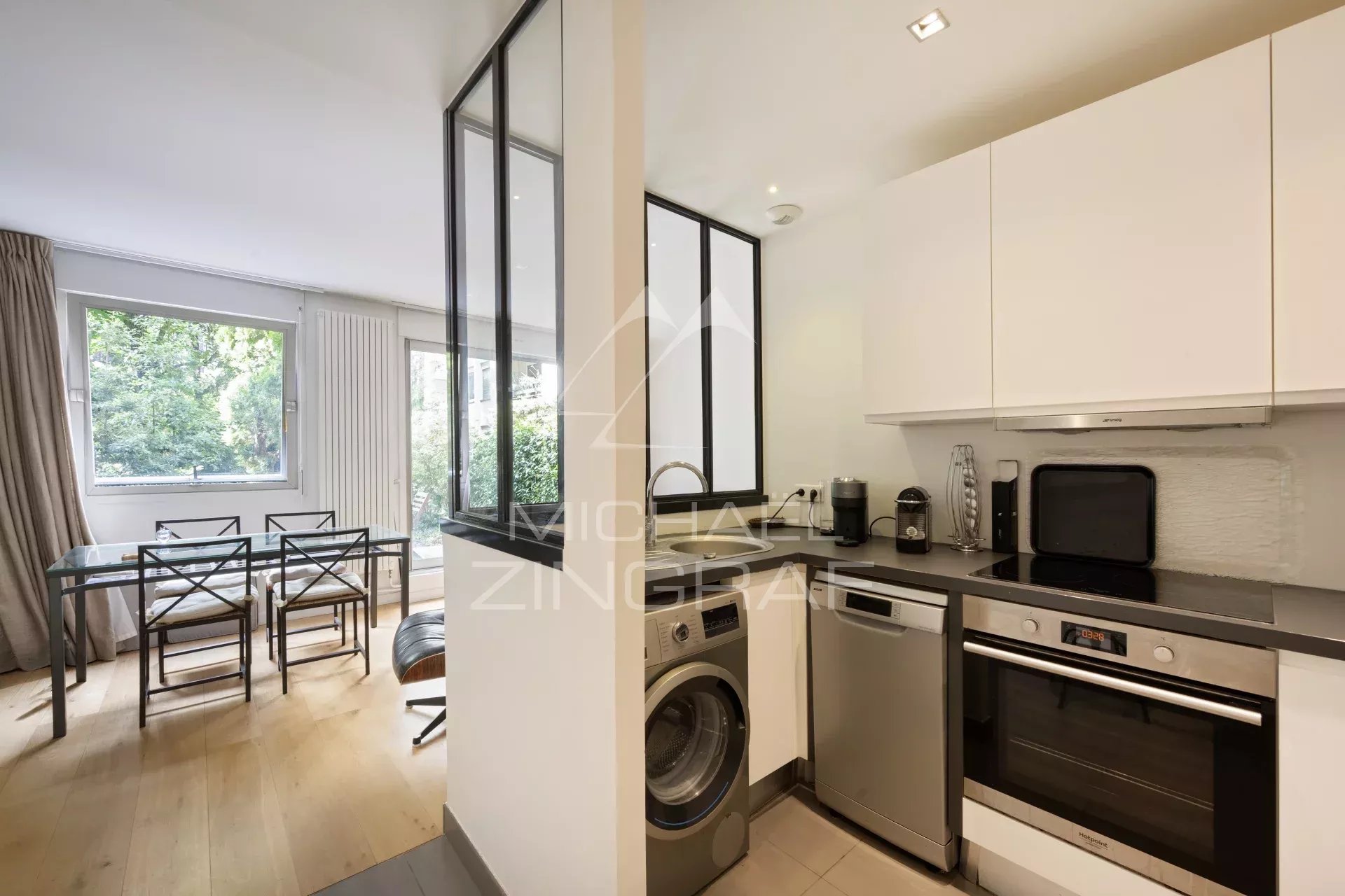 Cuisine d’un appartement à Neuilly-sur-Seine Cuisine moderne avec coin repas, ouverte sur un jardin, dans un appartement à Neuilly-sur-Seine.