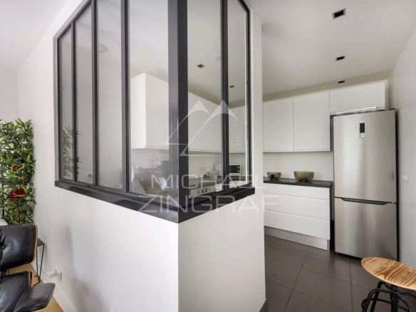 Cuisine moderne avec un espace ouvert sur le salon, mobilier contemporain, lumière naturelle.