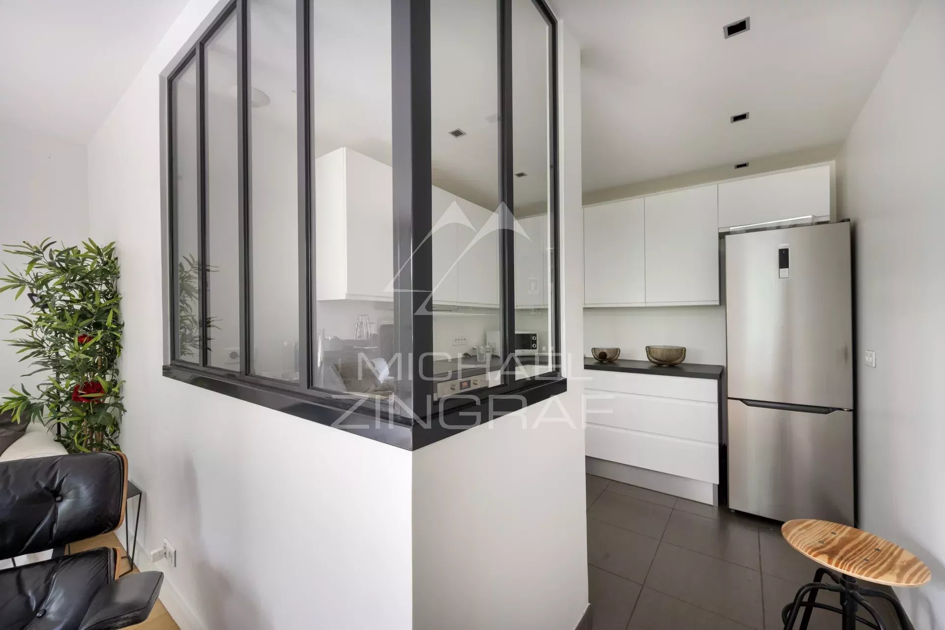 Cuisine ouverte dans un appartement à Neuilly-sur-Seine Cuisine moderne avec un espace ouvert sur le salon, mobilier contemporain, lumière naturelle.