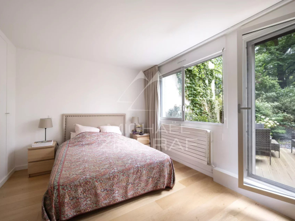 Chambre d'un appartement en rez-de-jardin avec accès à un espace extérieur.
