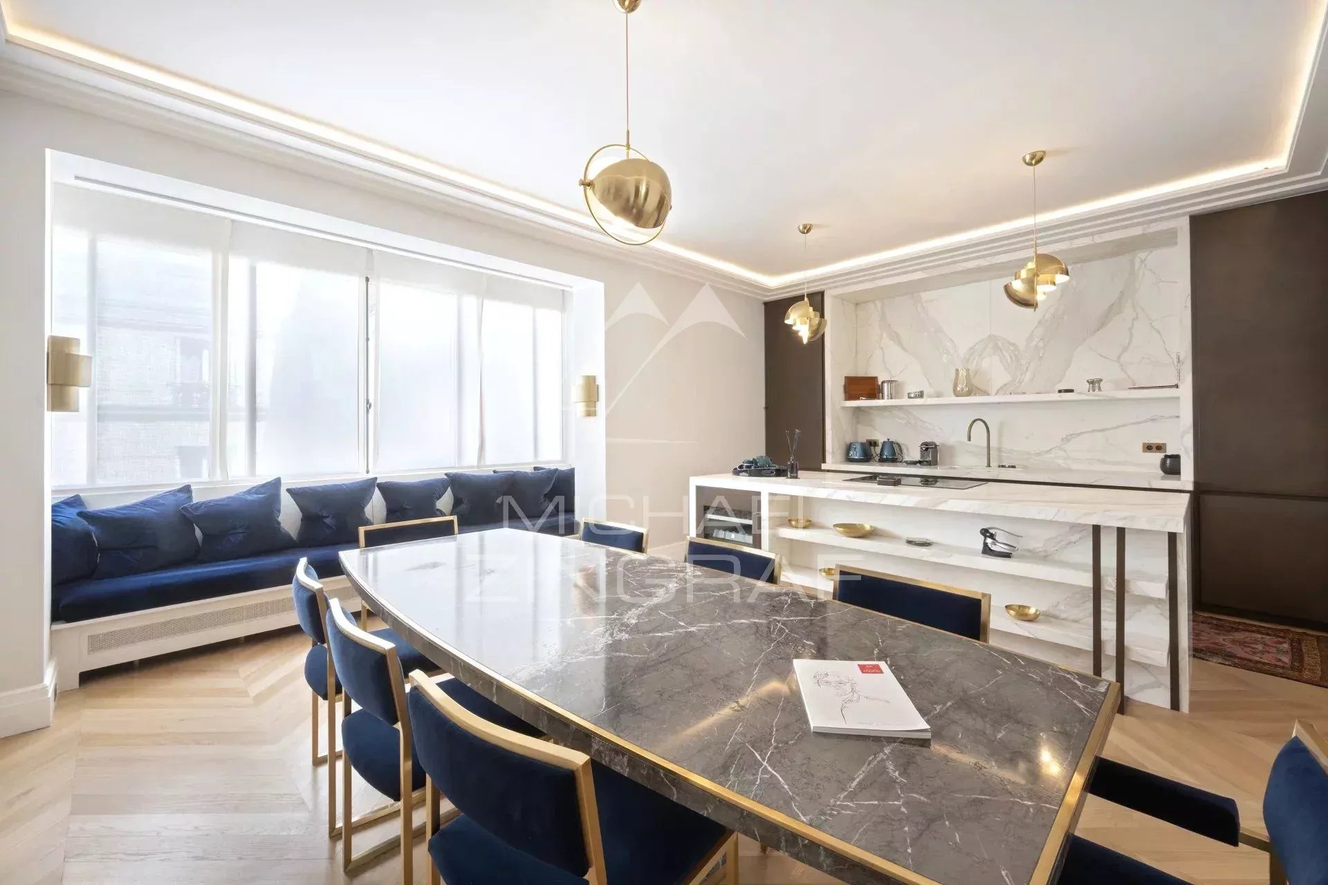 Appartement rénové à Paris 8ème Intérieur d'un appartement moderne avec une table à manger en marbre et un coin salon lumineux.