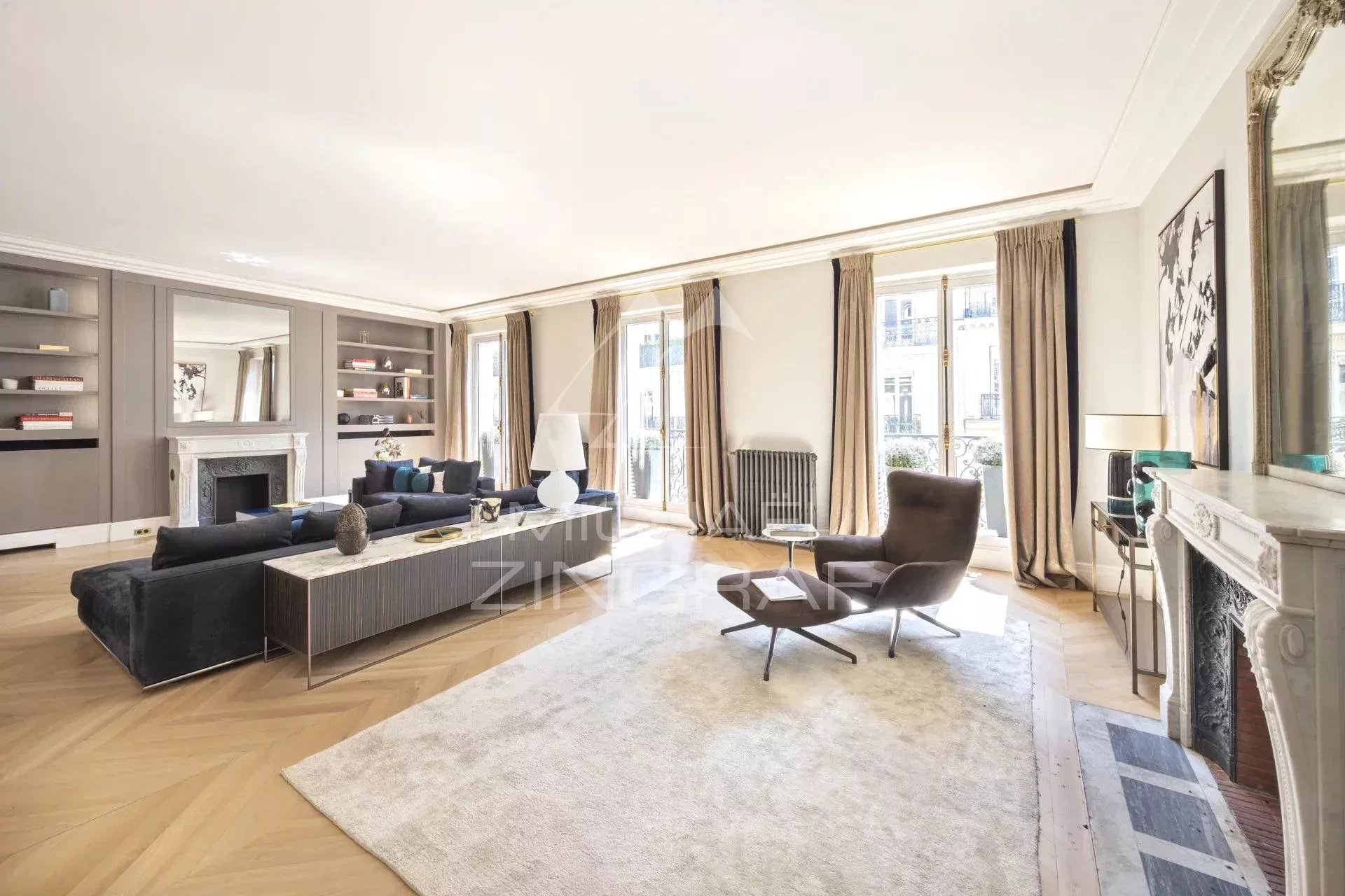 Appartement rénové à Paris 8ème Intérieur d'un appartement rénové avec salon spacieux et lumineux, parquet en bois et grandes fenêtres.