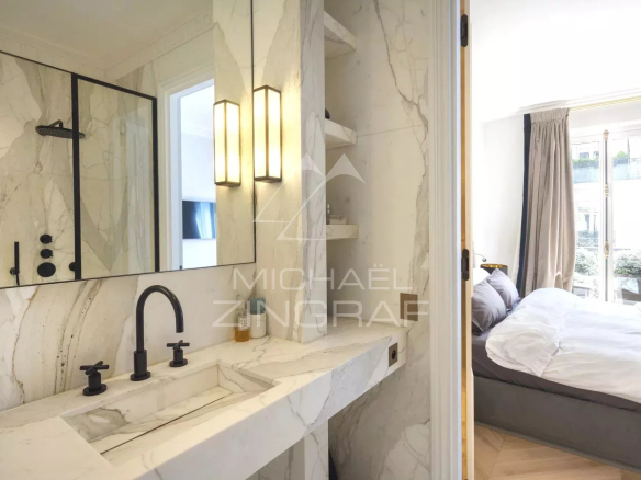 Salle de bain moderne avec lavabo en marbre et miroir, appartement refait à neuf à Paris 8ème.