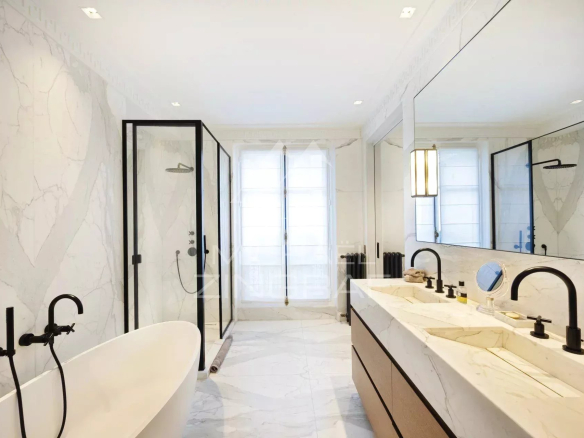 Salle de bain moderne avec baignoire, douche et double vasque en marbre