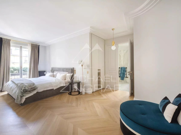 Chambre d'un appartement refait à neuf avec parquet, lit et canapé, Paris 8ème.