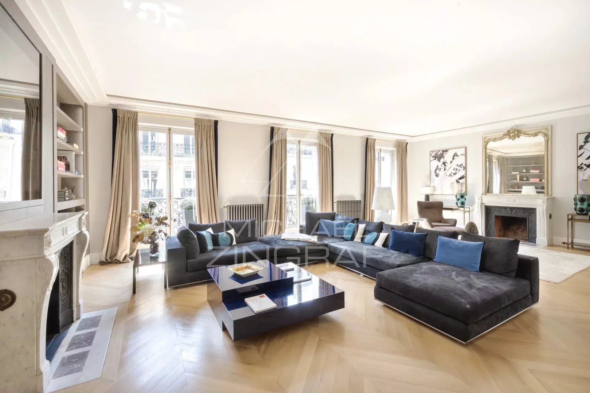 Salon d’un appartement refait à neuf à Paris Salon spacieux d'un appartement rénové à Paris, avec canapé moderne et cheminée.