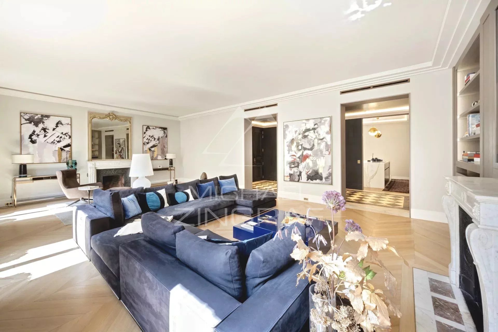 Salon d’un appartement rénové à Paris Salon spacieux d'un appartement rénové à Paris, avec canapé bleu et décoration élégante.