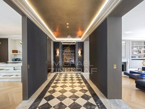 Entrée d'un appartement refait à neuf avec un sol en damier et un éclairage moderne à Paris 8ème.