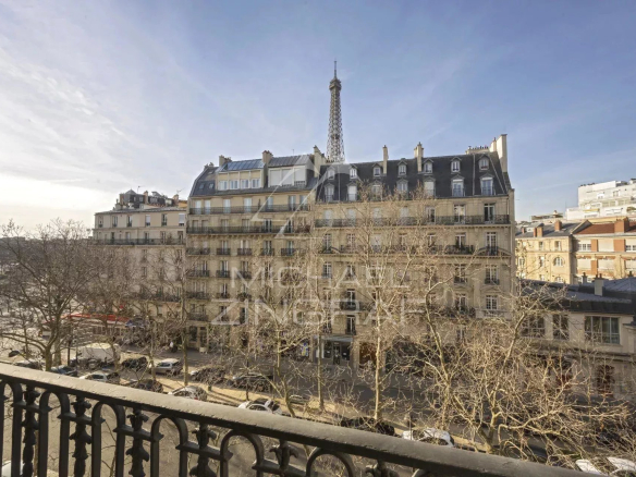 View of an old building in Paris with the Eiffel Tower in the background.