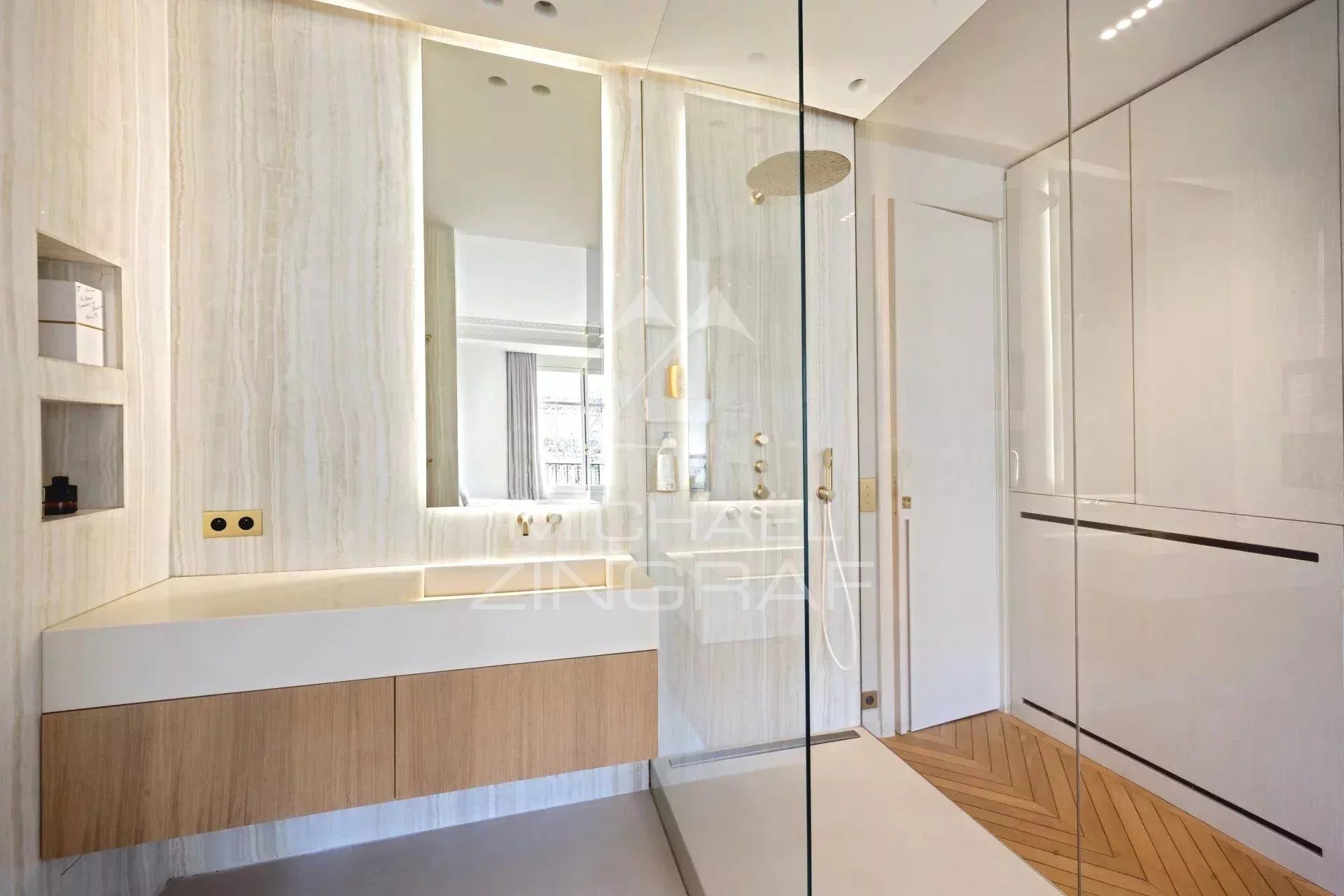 Bathroom of an apartment in the 7th arrondissement of Paris Modern bathroom with walk-in shower and wooden vanity unit.
