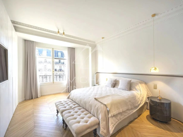 Renovated apartment room with parquet flooring and street-facing window in Paris 7th arrondissement.