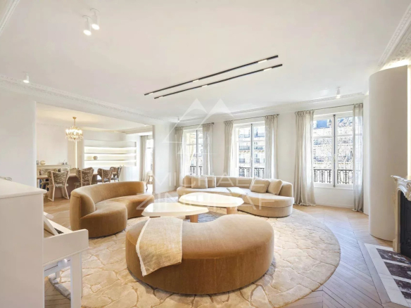Spacious living room in a reception apartment in Paris, with a U-shaped sofa and natural light.