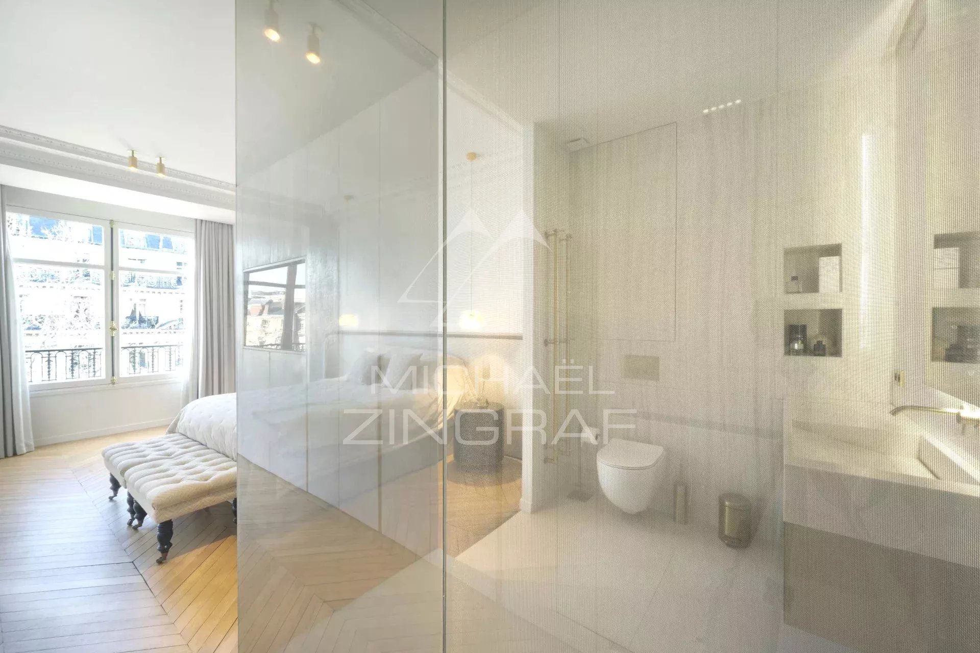 Bathroom and bedroom in Paris 7th arrondissement Modern bathroom with shower and toilet, overlooking a bright bedroom in Paris 7th arrondissement.