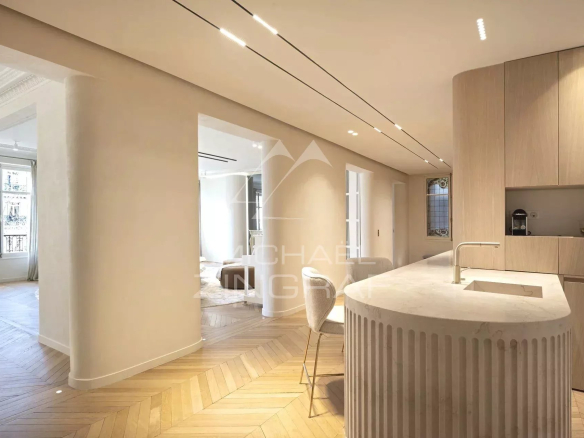 Interior of a modern apartment with open kitchen and parquet flooring, Paris 7th arrondissement.