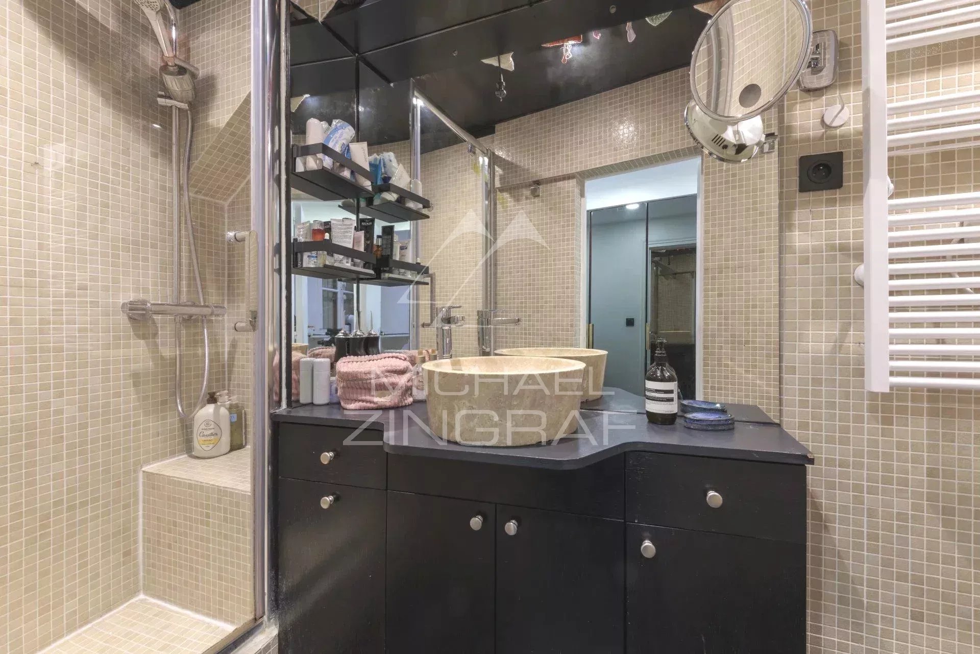 Salle de bain d’un appartement à Paris Salle de bain moderne avec douche, lavabo et miroir, dans un appartement rénové à Paris.