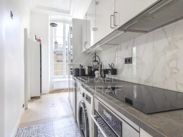 Cuisine moderne d'un appartement à Paris, avec des appareils électroménagers et un sol en carrelage.