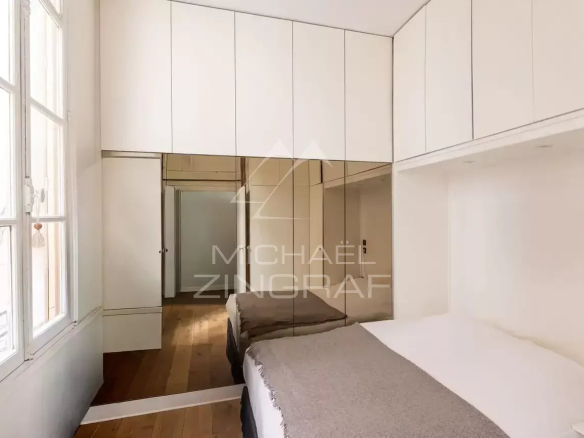 Chambre d'un appartement rénové avec lit et placards intégrés, Paris 7ème.
