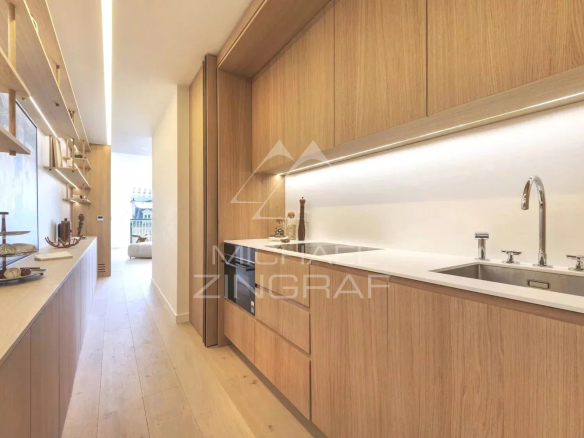 Cuisine moderne et lumineuse d'un appartement rénové à Paris, avec meubles en bois clair.