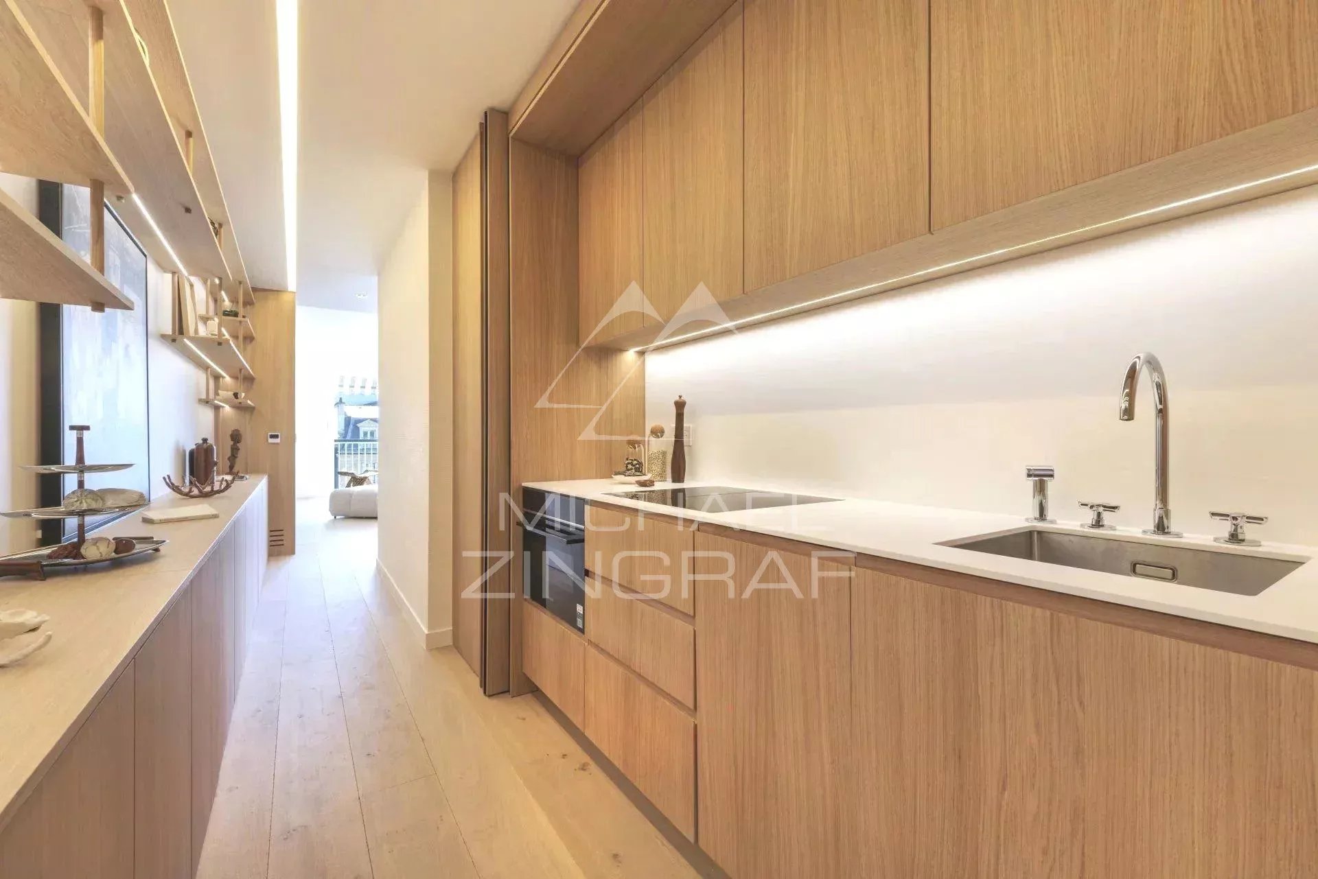 Cuisine moderne et lumineuse d'un appartement rénové à Paris, avec meubles en bois clair.