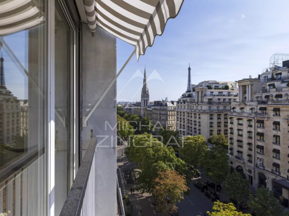Vue depuis un appartement au 7ème étage sur l'Avenue George V à Paris, avec des bâtiments haussmanniens et la tour Eiffel en arrière-plan.