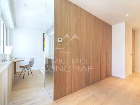 Intérieur d'un appartement rénové avec mobilier moderne, parquet clair et murs blancs.