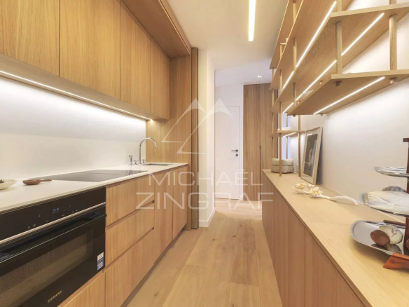 Cuisine moderne et rénovée dans un appartement à Paris, avec des meubles en bois clair et des équipements modernes.