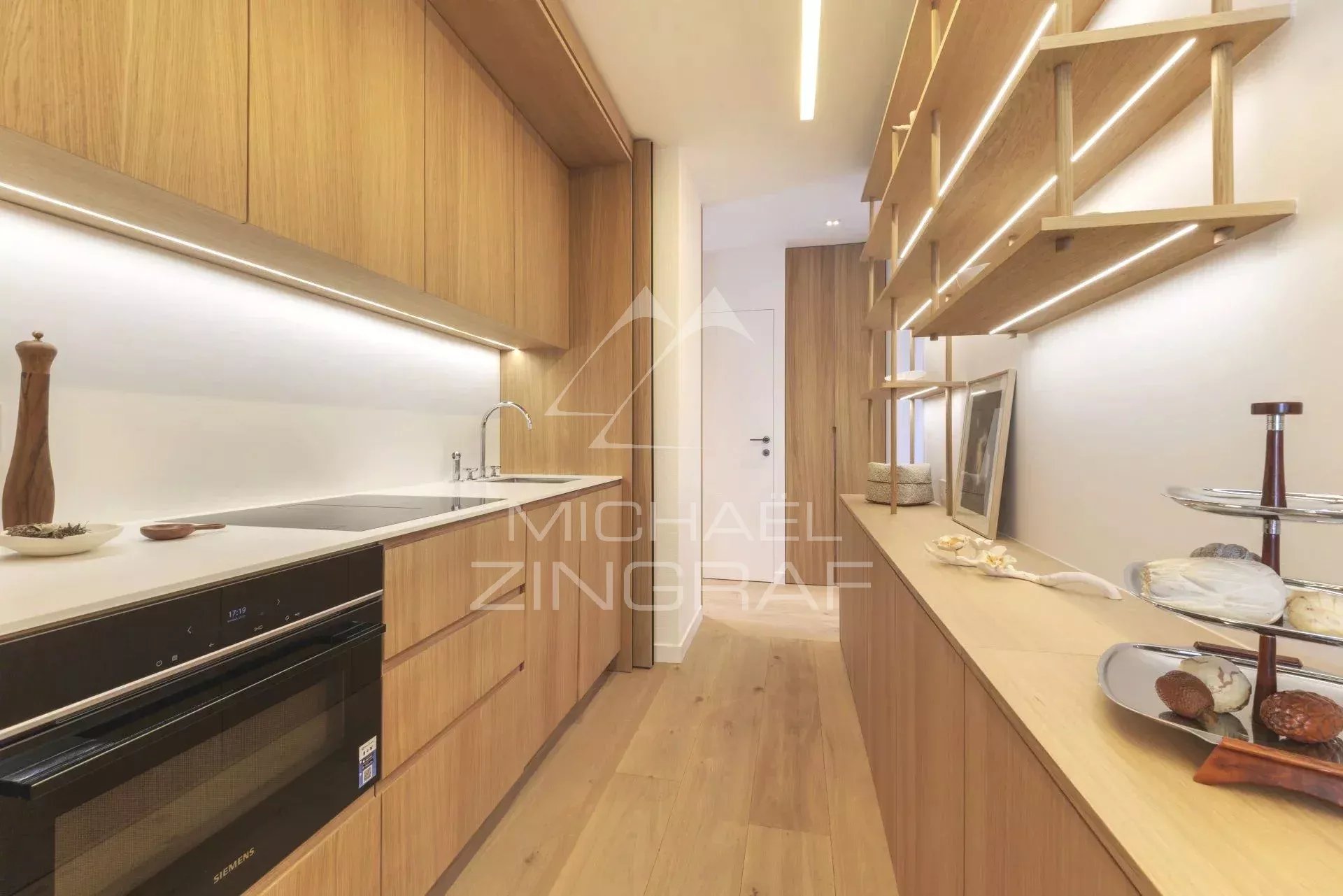 Cuisine moderne et rénovée dans un appartement à Paris, avec des meubles en bois clair et des équipements modernes.