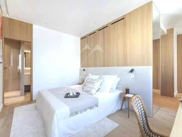 Chambre d'un appartement rénové à Paris, avec lit et décoration moderne.