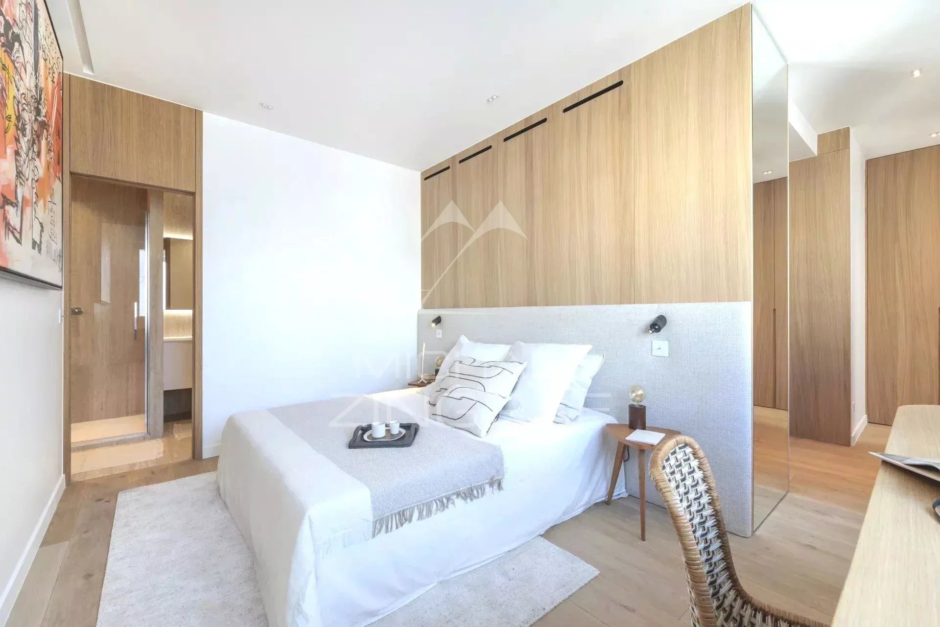 Chambre d'un appartement rénové à Paris, avec lit et décoration moderne.