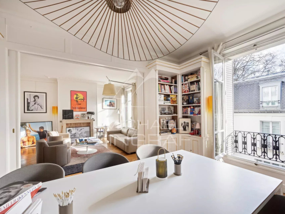 Intérieur d'un appartement à Paris avec salle à manger, espace de réception et bibliothèque.