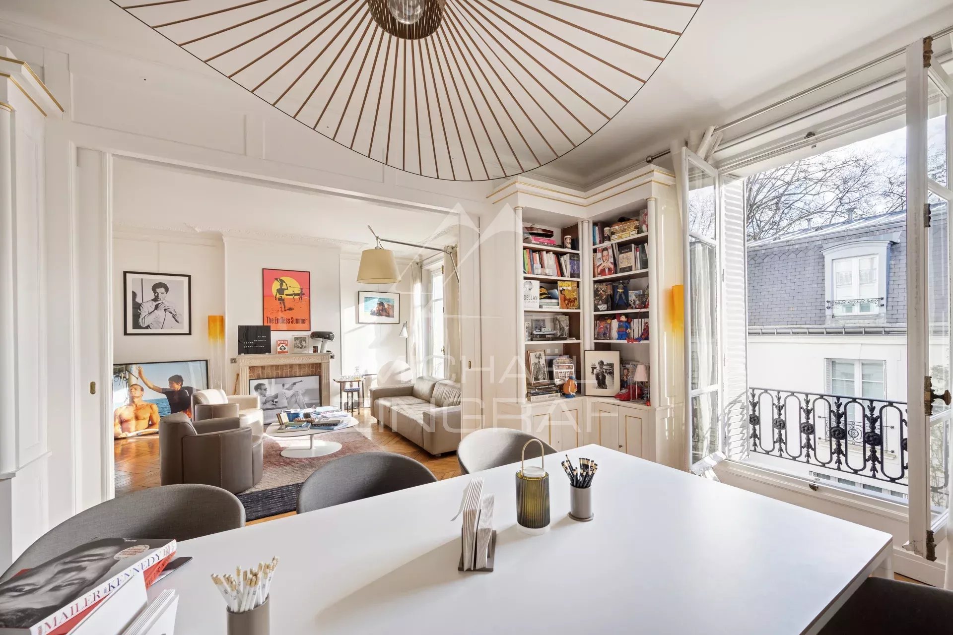 Intérieur d'un appartement à Paris avec salle à manger, espace de réception et bibliothèque.