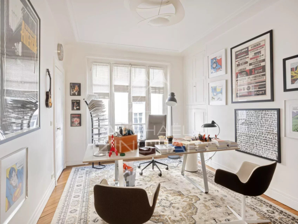 Bureau lumineux dans un appartement à Paris, avec des œuvres d'art et un mobilier moderne.