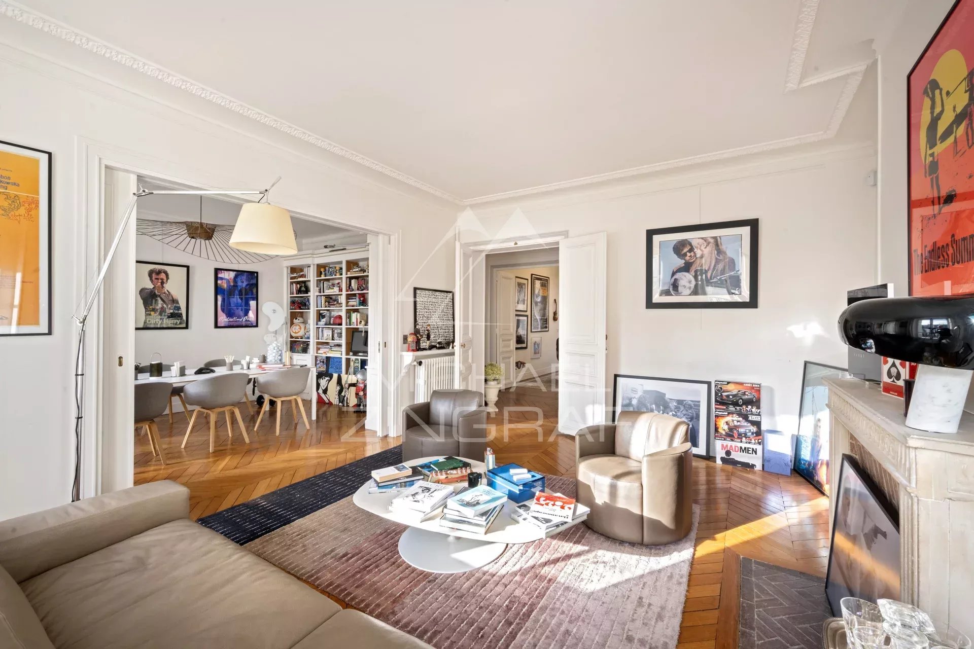Salon lumineux avec cheminée et espace de réception dans un appartement à Paris 7ème.