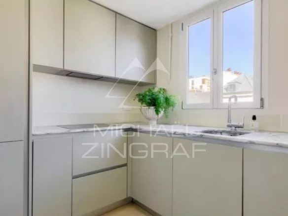 Modern kitchen in an apartment in the 7th arrondissement of Paris, with windows and a marble worktop.