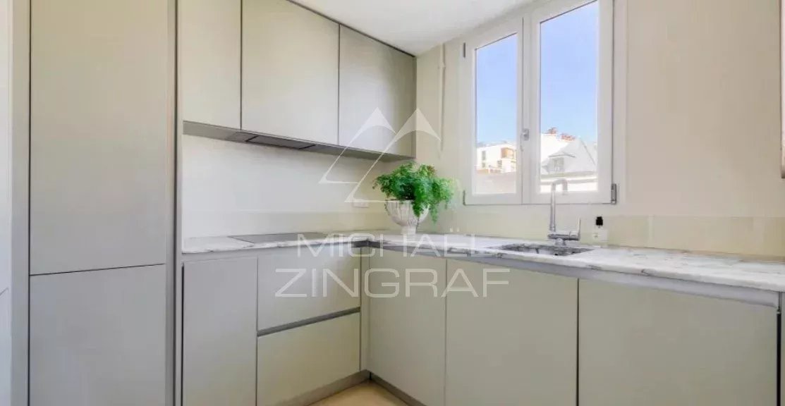 Kitchen of an apartment in the 7th arrondissement of Paris Modern kitchen in an apartment in the 7th arrondissement of Paris, with windows and a marble worktop.