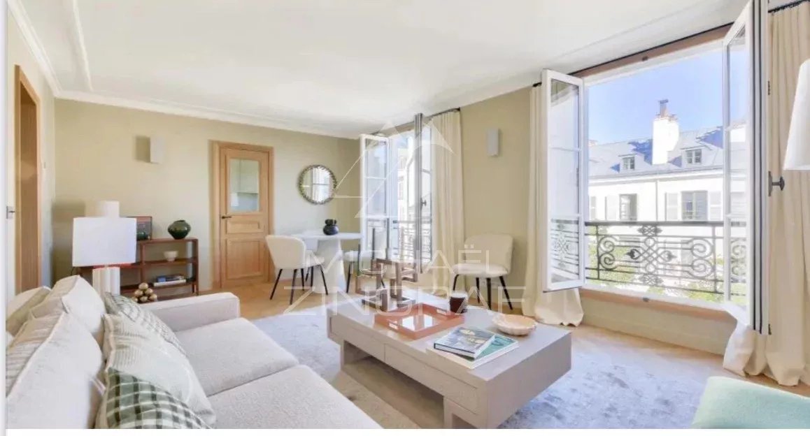 Apartment living room in Paris Bright living room of a furnished apartment in Paris with open windows and garden views.