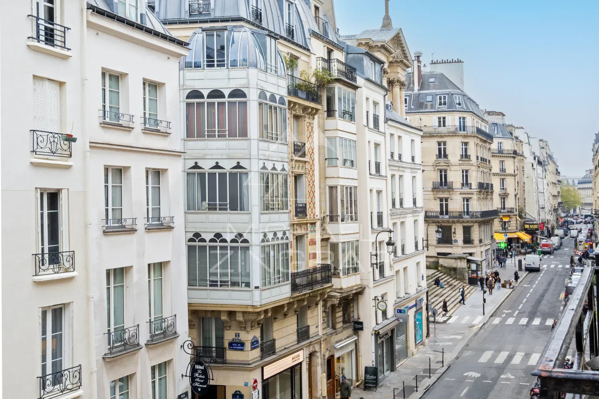 Vue de la rue Saint Honoré à Paris, montrant des bâtiments et des commerces.