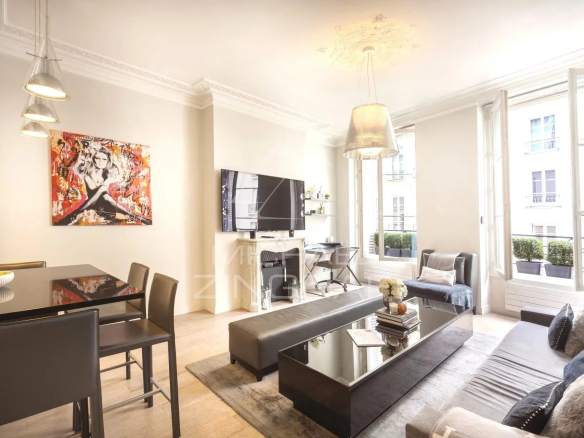 Intérieur d'un appartement moderne avec salon et cuisine ouverte, situé à Paris.