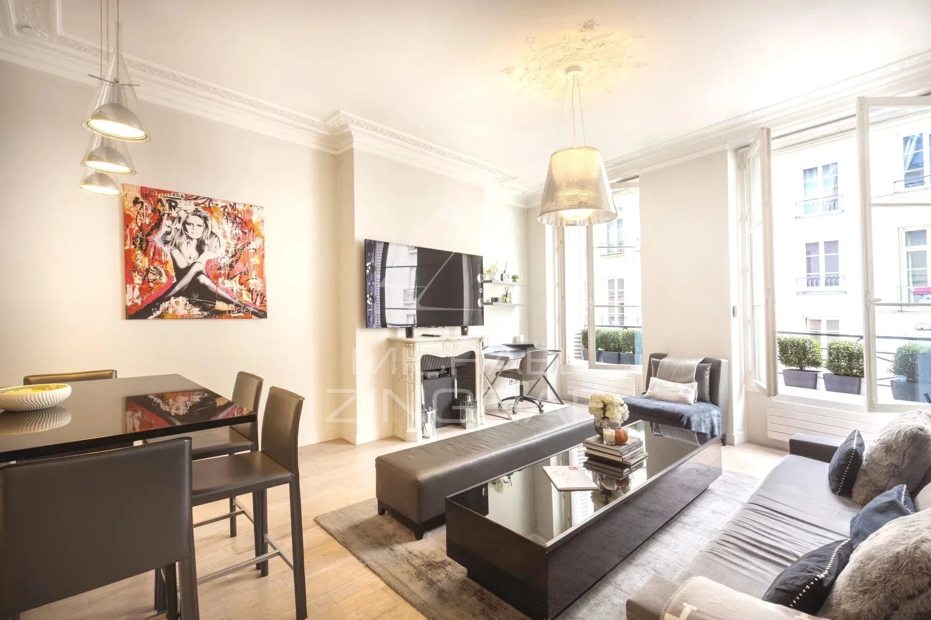 Intérieur d'un appartement moderne avec salon et cuisine ouverte, situé à Paris.