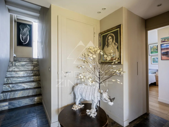 Intérieur d'un penthouse à Paris avec un escalier et une décoration artistique.