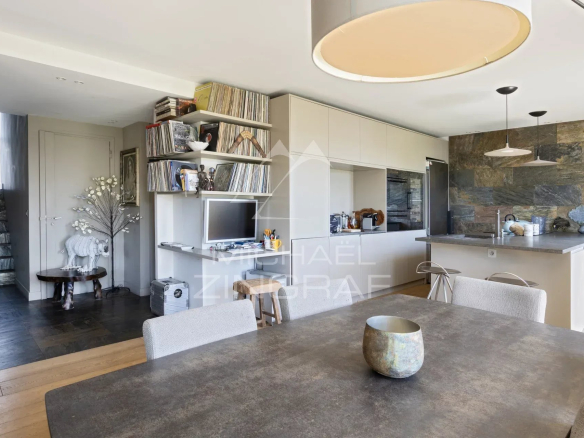 Intérieur d'un penthouse avec salle à manger, cuisine ouverte et décoration moderne.