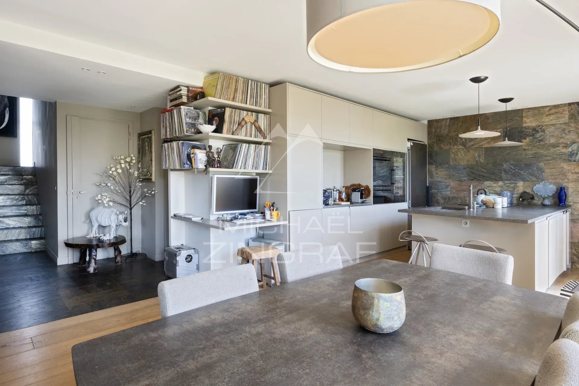 Intérieur d'un penthouse avec salle à manger, cuisine ouverte et décoration moderne.
