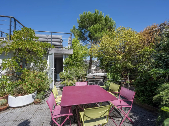 Terrasse d'un penthouse avec mobilier coloré et verdure, Paris 15ème.