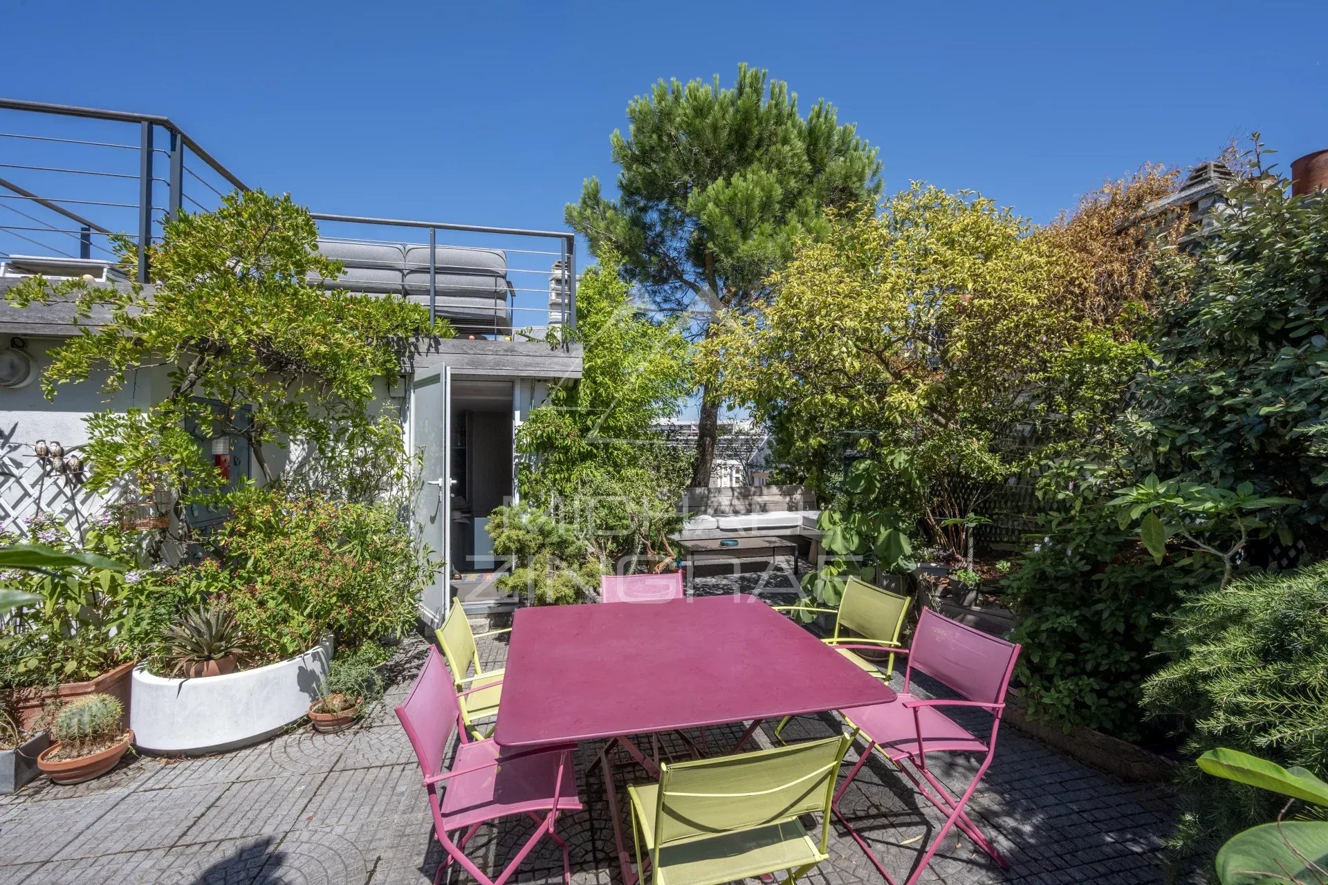 Terrasse d'un penthouse avec mobilier coloré et verdure, Paris 15ème.