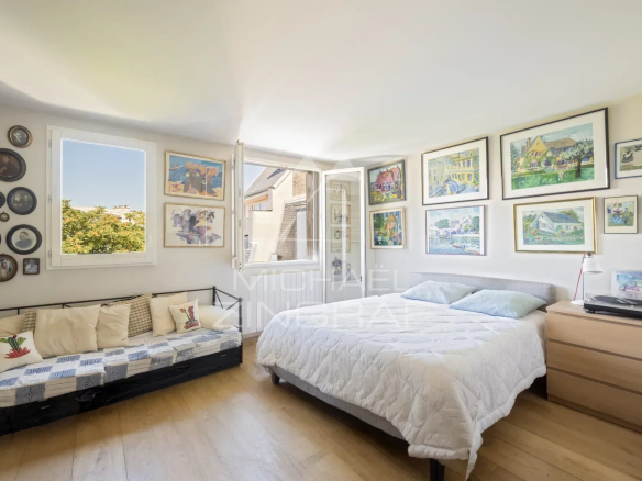 Chambre d'un penthouse à Paris 15 avec décorations murales et lit.