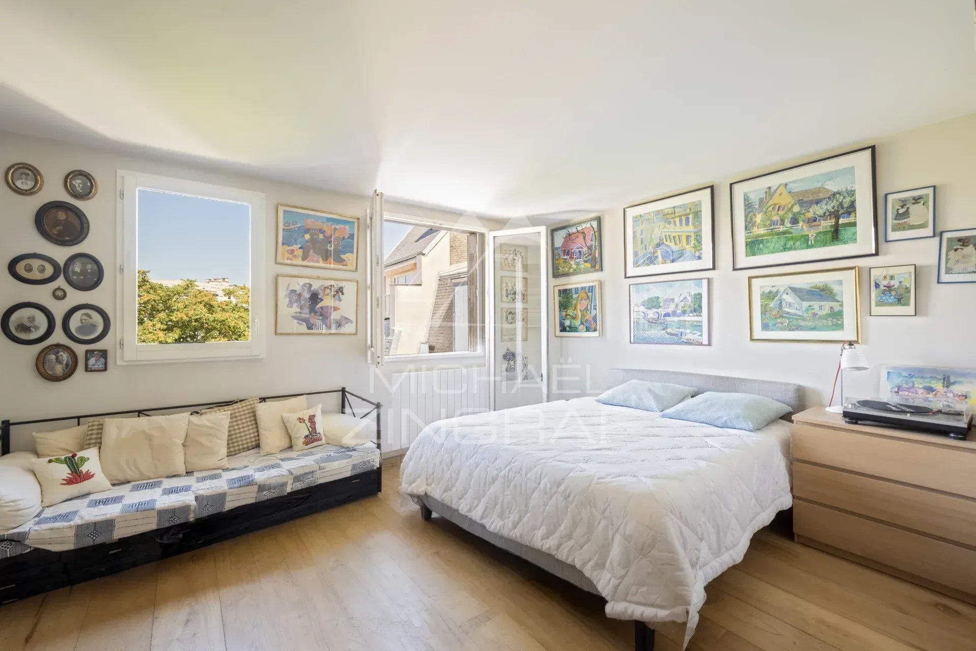 Chambre d'un penthouse à Paris 15 avec décorations murales et lit.