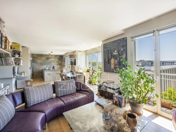 Intérieur d'un penthouse avec salon, cuisine ouverte et accès à un rooftop.