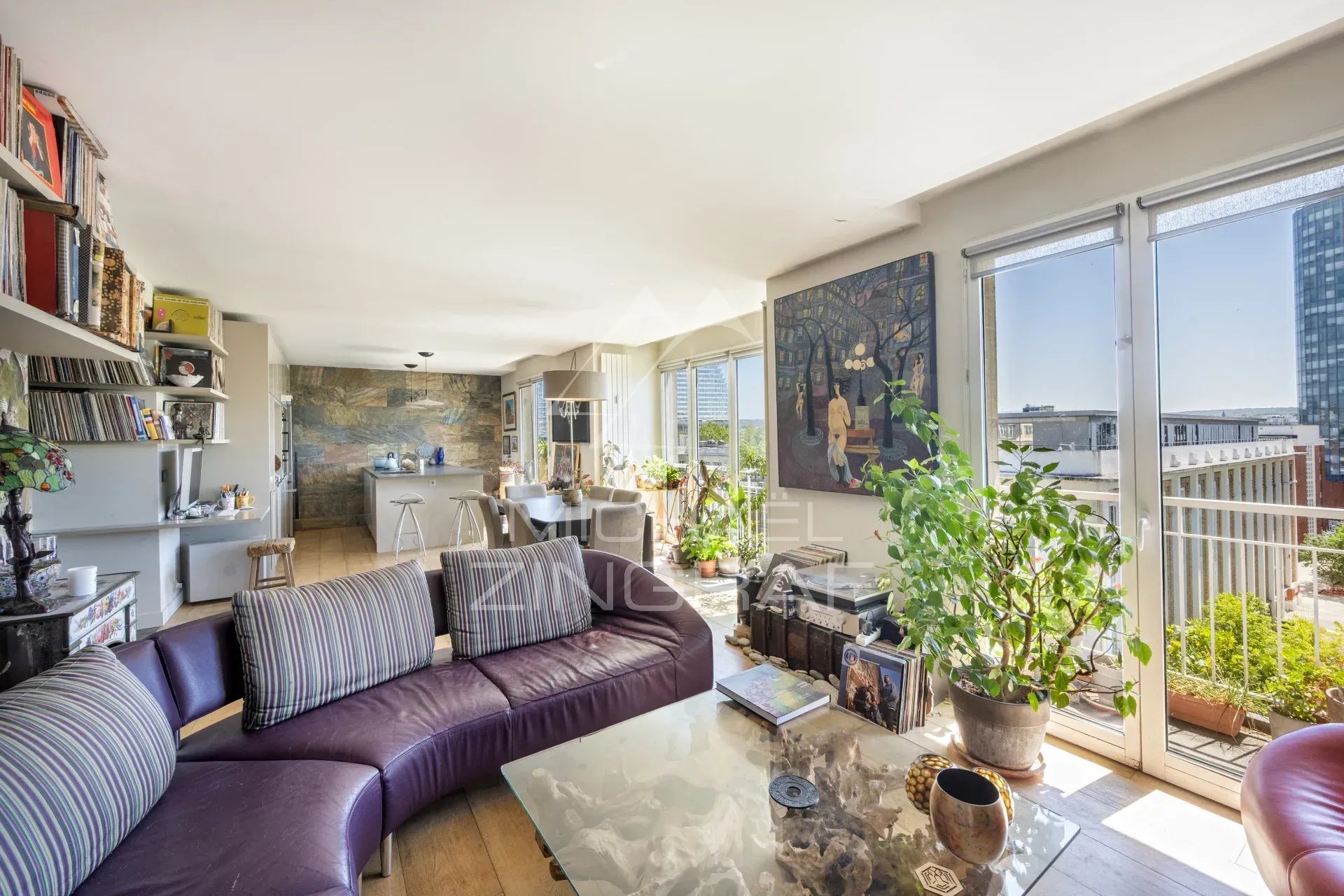 Intérieur d'un penthouse avec salon, cuisine ouverte et accès à un rooftop.