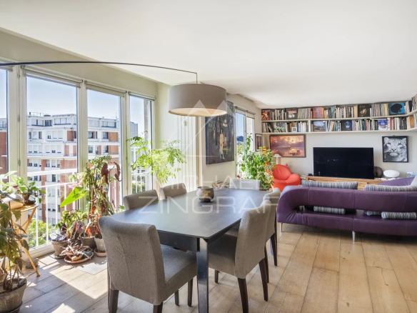 Intérieur d'un penthouse à Paris 15, salon avec table à manger et plantes.
